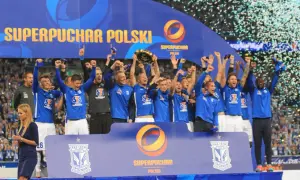 Piłkarze świętują zdobycie Superpucharu Polski, unosząc trofeum i ciesząc się deszczem konfetti.