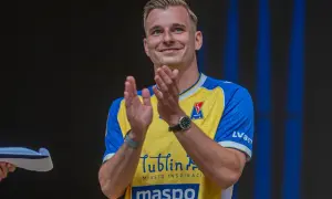 Uśmiechnięty Mateusz Legowski w żółto-niebieskiej koszulce z logo Motor Lublin klaszcze, świętując sukces.