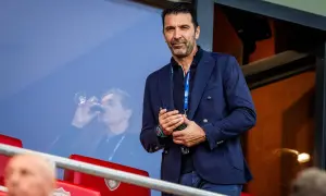 Gianluigi Buffon, jeden z najlepszych włoskich bramkarzy, w eleganckim garniturze obserwuje mecz.
