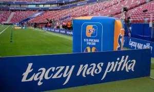 Stadion przed meczem STS Puchar Polski. Na zielonej murawie i trybunach widać logotypy i hasło "Łączy nas piłka".