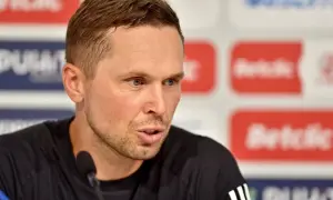 Piotr Klepczarek, z niebieskimi oczami i krótkimi włosami, mówi do mikrofonu na tle logotypów.