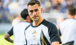 Juventus – zawodnicy. Skupiony piłkarz w koszulce z logo klubu i sponsorem Allianz, gotowy do gry.