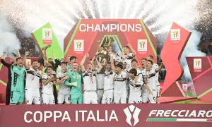 Bologna FC świętuje zwycięstwo w rozgrywkach Coppa Italia, wznosząc puchar na tle fajerwerków i napisu "CHAMPIONS".