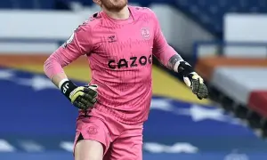 Jordan Pickford, bramkarz Anglii, w różowym stroju Evertonu, gotowy do obrony.