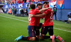 Piłkarze Osasuna FC świętują zwycięstwo, przytulając się na boisku.