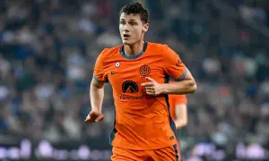 Benjamin Pavard w pomarańczowej koszulce Interu biegnie po boisku, skupiony na grze.
