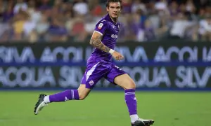 Franco Mastantuono w fioletowym stroju Fiorentiny biegnie po boisku, z tatuażem na ramieniu i skupionym spojrzeniem.