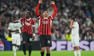 Piłkarz AC Milan z podniesionymi rękami świętuje zwycięstwo nad Realem Madryt.