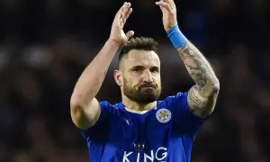 Piłkarz Leicester City, jeden z zawodników Premier League, z tatuażami na ramieniu, klaszcze po meczu.