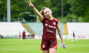 Weronika Zawistowska w dresie reprezentacji Polski, z butelką wody w dłoni, pokazuje znak pokoju.