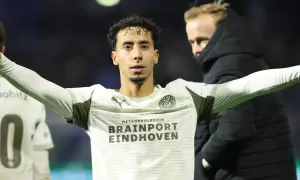 Jerdy Schouten w białej koszulce z logo PSV Eindhoven, z rękami rozłożonymi na boki.