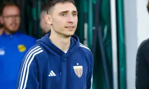 Jakub Arak w granatowej bluzie z herbem Polonii Bytom, gotowy do wyjścia na boisko.