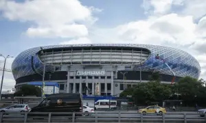 Nowoczesny stadion Dynamo Mińsk z charakterystyczną, geometryczną fasadą. Na dachu widać pracownika na wysięgniku.