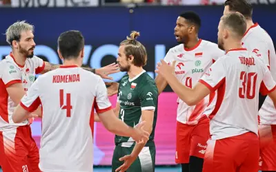 Siatkarze w białych strojach z czerwonymi elementami i jeden w zielonym, świętują zwycięstwo. To ważne mecze dla reprezentacji Polski, która walczy o kolejne punkty.