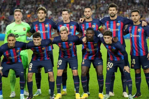 FC Barcelona – zawodnicy w swoich granatowo-bordowych strojach pozują do zdjęcia na murawie.