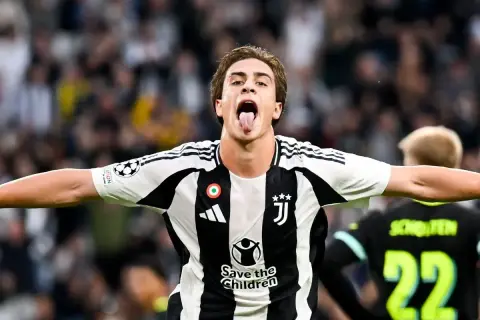 Kenan Yıldız w koszulce Juventusu świętuje bramkę, pokazując język.