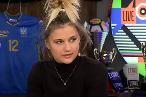 Oliwia Szperkowska w czarnym golfie, z piłkarską koszulką Ukrainy i trofeami w tle.