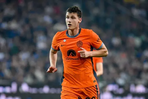 Benjamin Pavard w pomarańczowej koszulce Interu biegnie po boisku, skupiony na grze.
