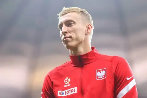 Adam Buksa w czerwonej bluzie reprezentacji Polski, z orłem na piersi.