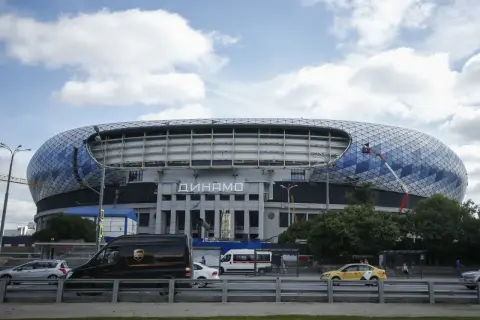 Nowoczesny stadion Dynamo Mińsk z charakterystyczną, geometryczną fasadą. Na dachu widać pracownika na wysięgniku.