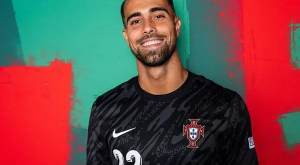 Uśmiechnięty Diogo Costa w czarnej koszulce reprezentacji Portugalii z numerem 22.