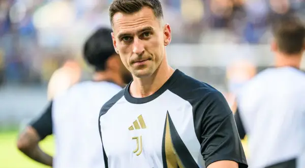 Juventus – zawodnicy. Skupiony piłkarz w koszulce z logo klubu i sponsorem Allianz, gotowy do gry.