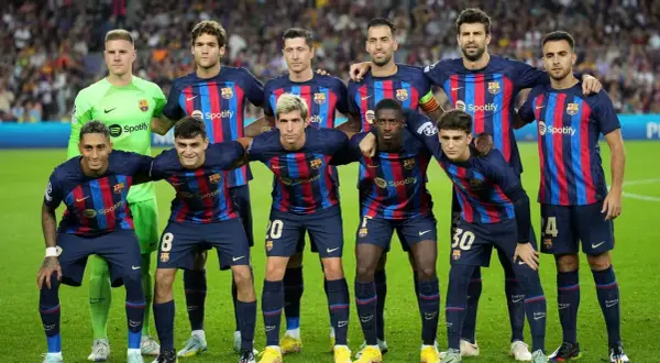 FC Barcelona – zawodnicy w swoich granatowo-bordowych strojach pozują do zdjęcia na murawie.
