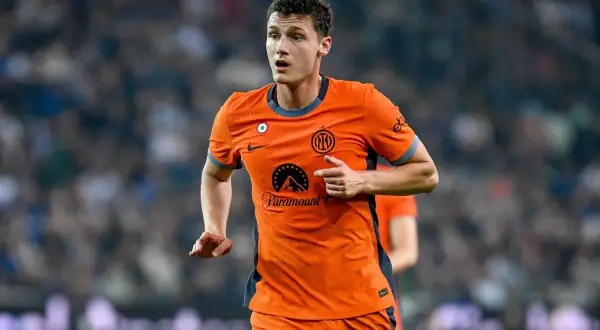 Benjamin Pavard w pomarańczowej koszulce Interu biegnie po boisku, skupiony na grze.