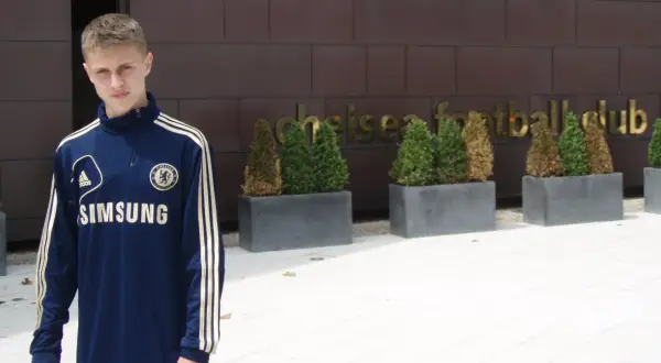 Młody Hubert Adamczyk w dresie Chelsea przed klubem.