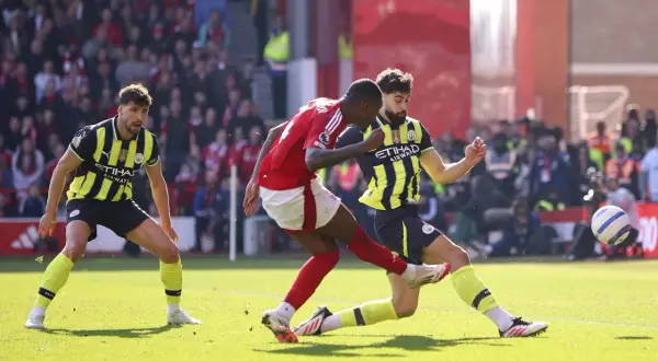 Piłkarze Nottingham Forest i Man City walczą o piłkę na boisku.
