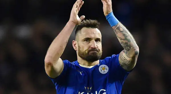 Piłkarz Leicester City, jeden z zawodników Premier League, z tatuażami na ramieniu, klaszcze po meczu.