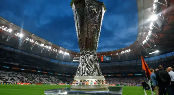 Trofeum Ligi Europy na tle stadionu, symbol walki o awans w fazie play-off.