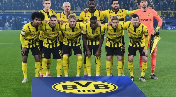 Borussia Dortmund – zawodnicy w żółto-czarnych strojach pozują do zdjęcia na murawie, prezentując dumę z barw klubowych.