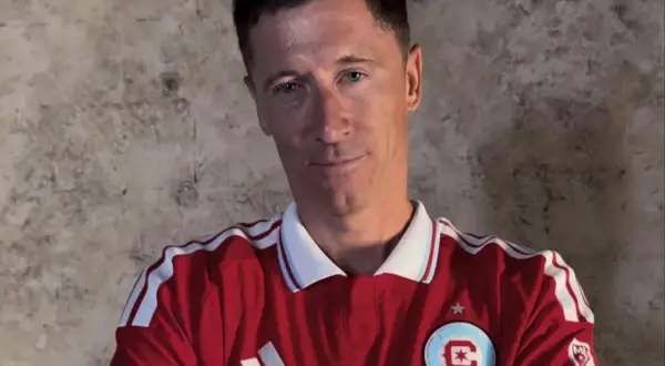 Robert Lewandowski w czerwonej koszulce z białymi pasami. W jakich klubach grał Lewandowski? Lech Poznań, Borussia Dortmund, Bayern Monachium, FC Barcelona.