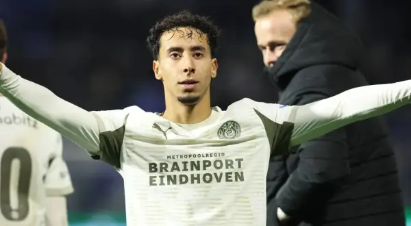 Jerdy Schouten w białej koszulce z logo PSV Eindhoven, z rękami rozłożonymi na boki.
