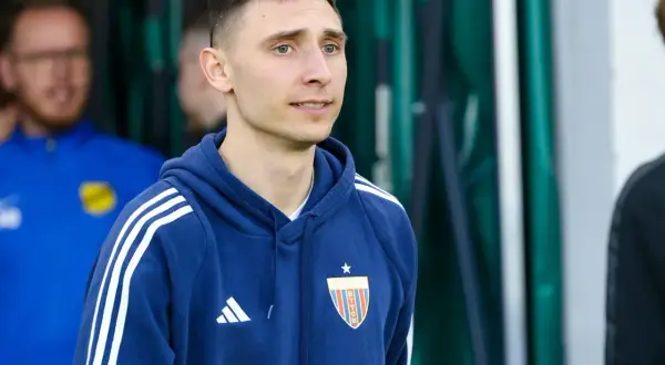 Jakub Arak w granatowej bluzie z herbem Polonii Bytom, gotowy do wyjścia na boisko.