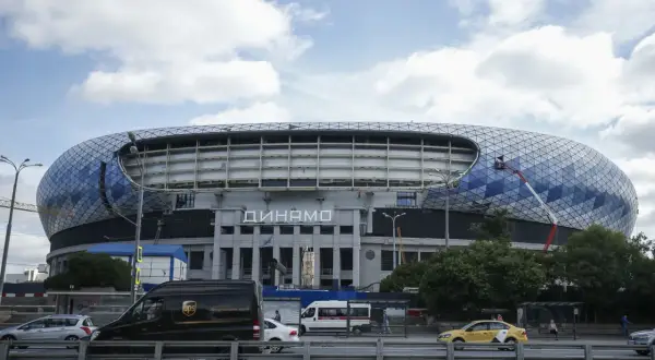 Nowoczesny stadion Dynamo Mińsk z charakterystyczną, geometryczną fasadą. Na dachu widać pracownika na wysięgniku.