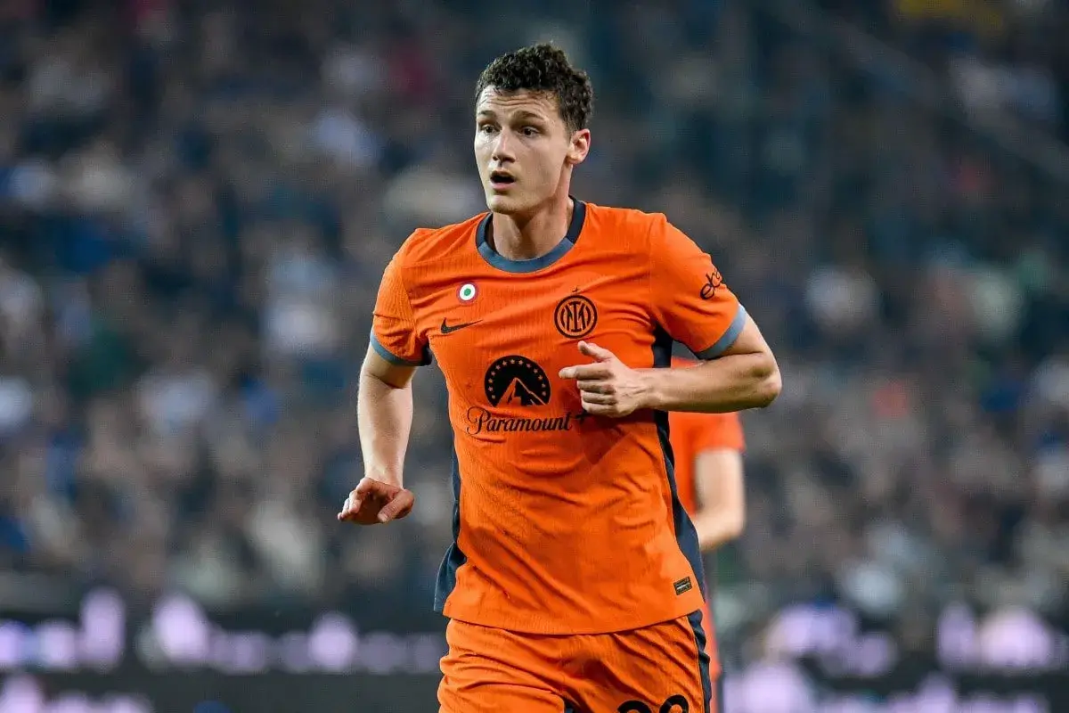 Benjamin Pavard w pomarańczowej koszulce Interu biegnie po boisku, skupiony na grze.