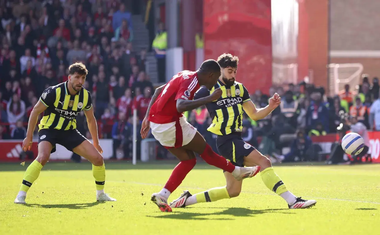 Piłkarze Nottingham Forest i Man City walczą o piłkę na boisku.