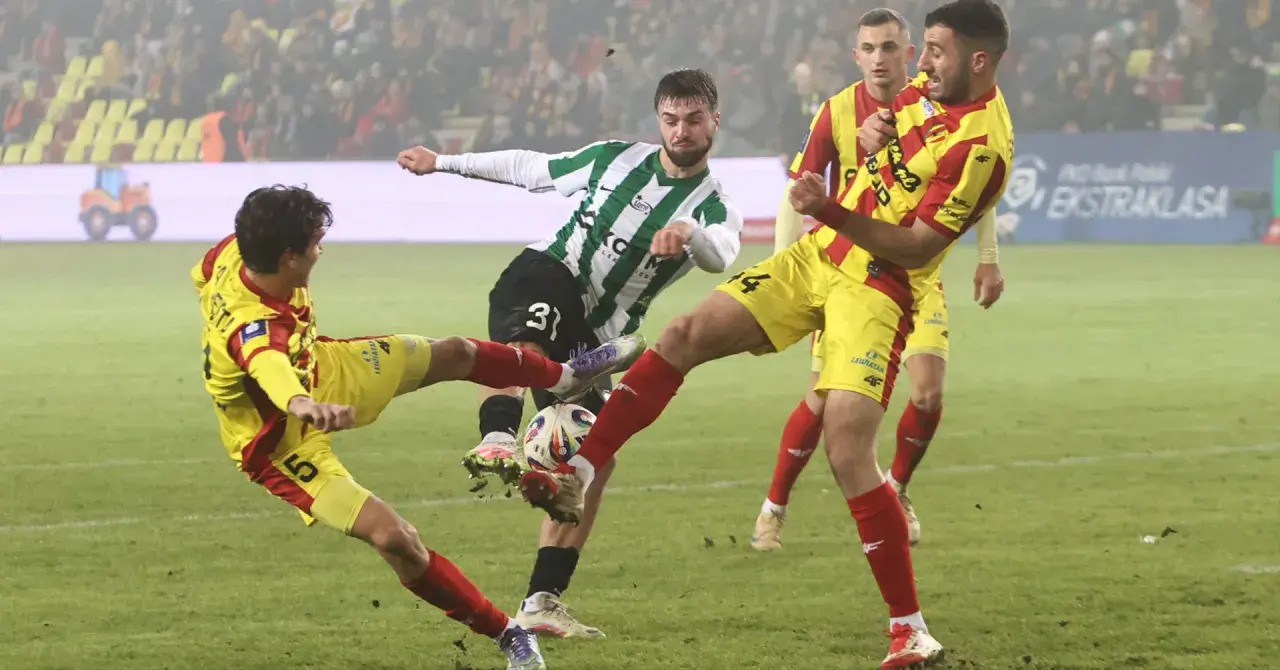 Zacięta walka o piłkę w meczu Korona Kielce – Zagłębie Lubin. Piłkarze w żółto-czerwonych strojach walczą z zawodnikiem w zielono-białej koszulce.