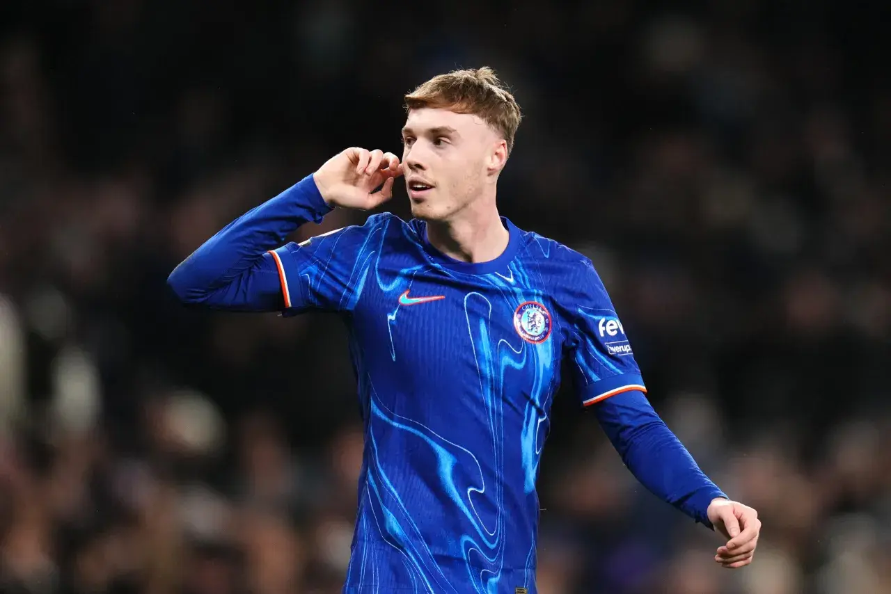 Młody piłkarz Cole Palmer w niebieskiej koszulce Chelsea z charakterystycznym wzorem, gestykuluje podczas meczu.