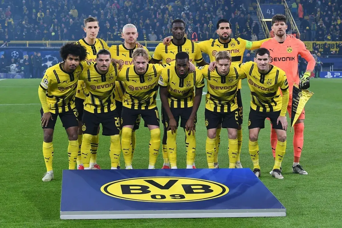 Borussia Dortmund – zawodnicy w żółto-czarnych strojach pozują do zdjęcia na murawie, prezentując dumę z barw klubowych.