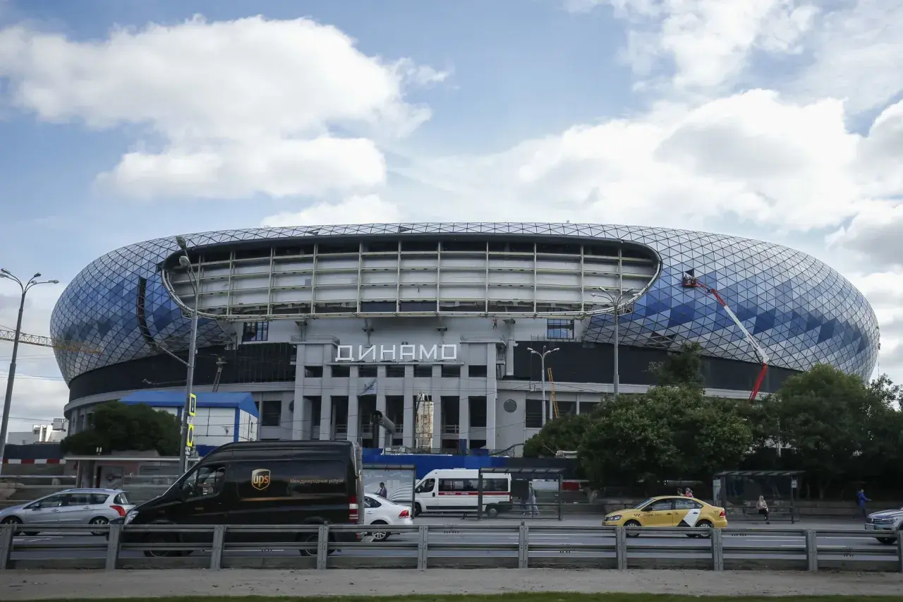 Nowoczesny stadion Dynamo Mińsk z charakterystyczną, geometryczną fasadą. Na dachu widać pracownika na wysięgniku.