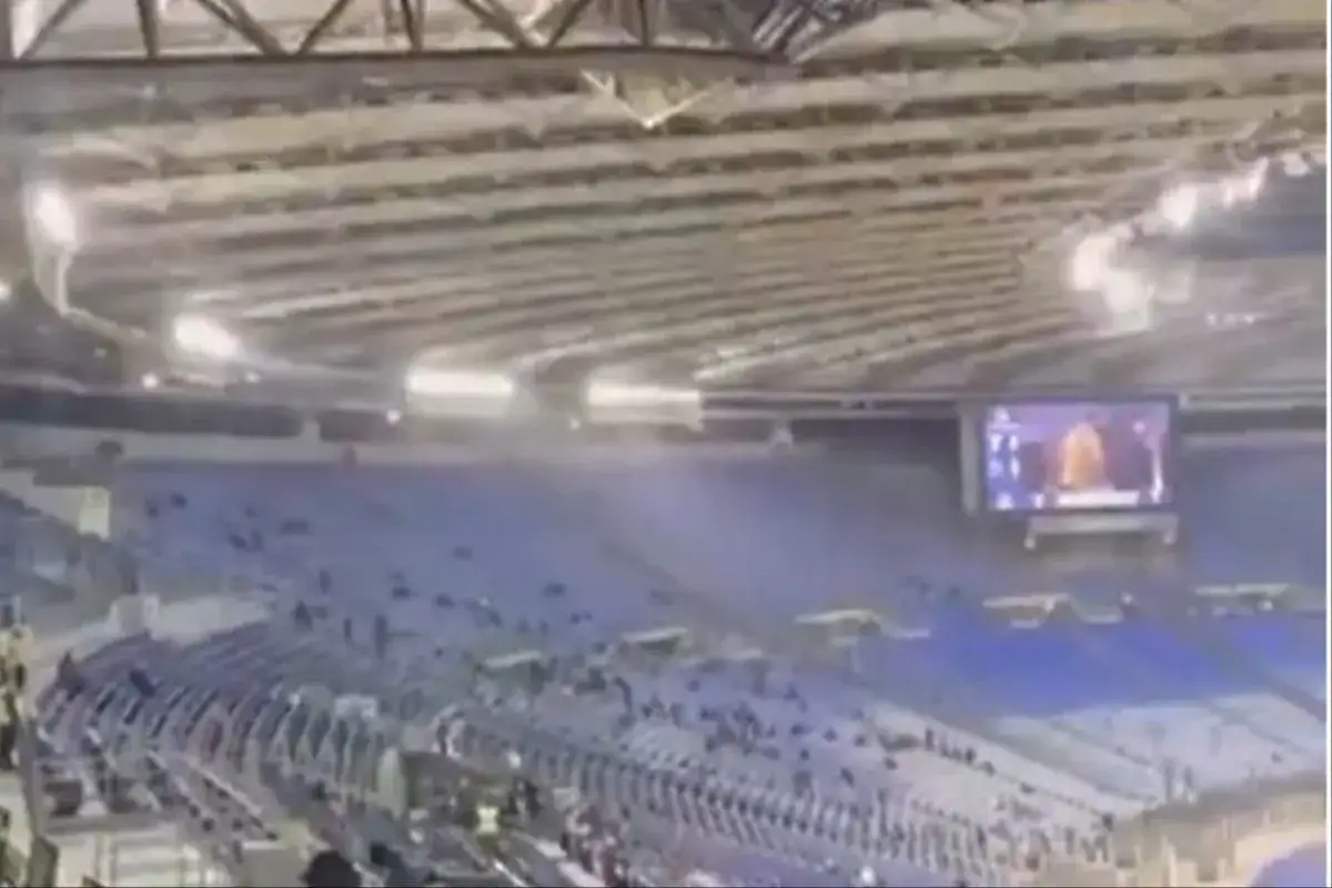 Puste trybuny stadionu Stadio Olimpico w Rzymie, gdzie gra Lazio. Na ekranie widać zawodnika.