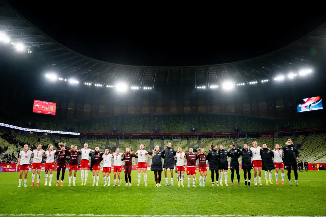 Piłkarki nożne Polski świętują zwycięstwo na stadionie.