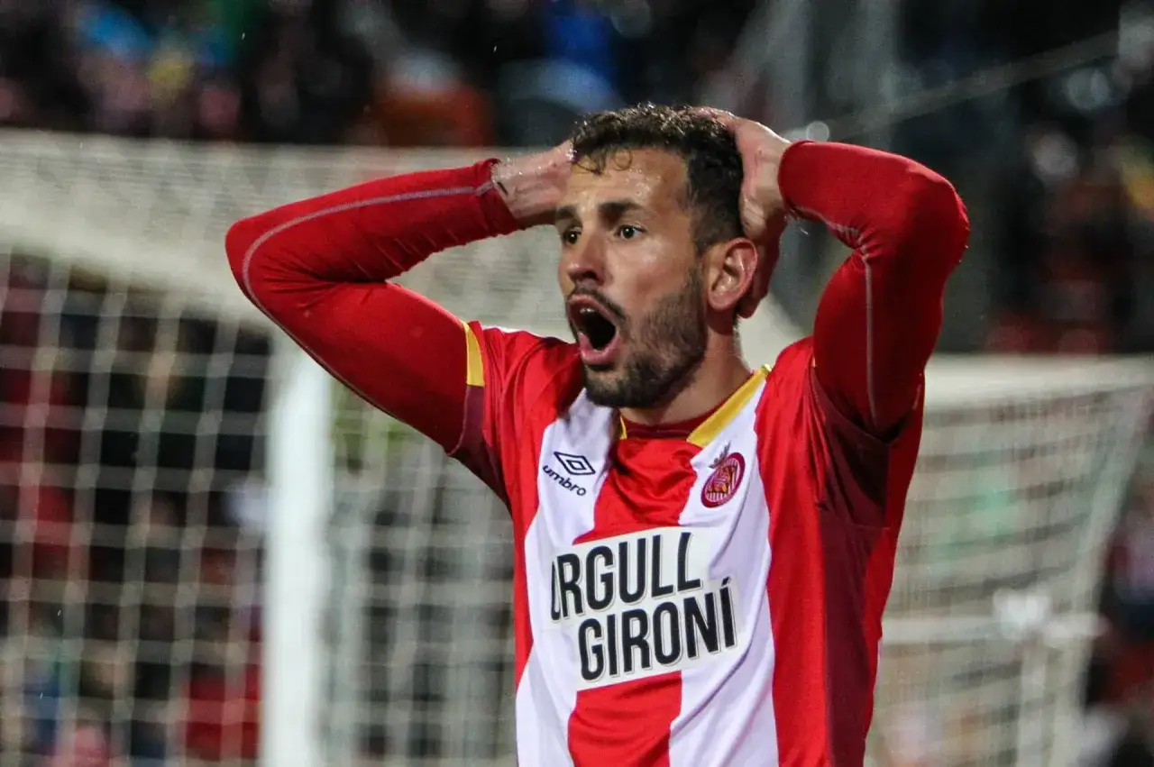 Girona FC &ndash; zawodnicy. Piłkarz w czerwonej koszulce z białymi pasami, z rękami na głowie, wyraża frustrację.