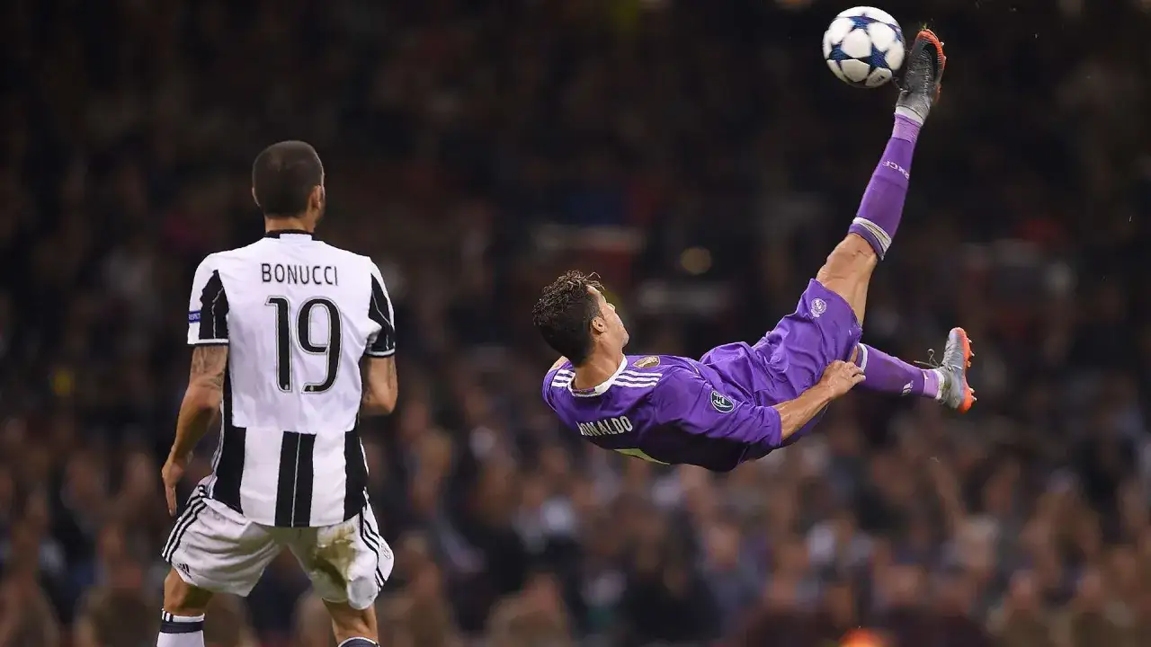 Cristiano Ronaldo wykonuje spektakularny gol z przewrotki, a obrońca Juventusu, Bonucci, patrzy z niedowierzaniem.