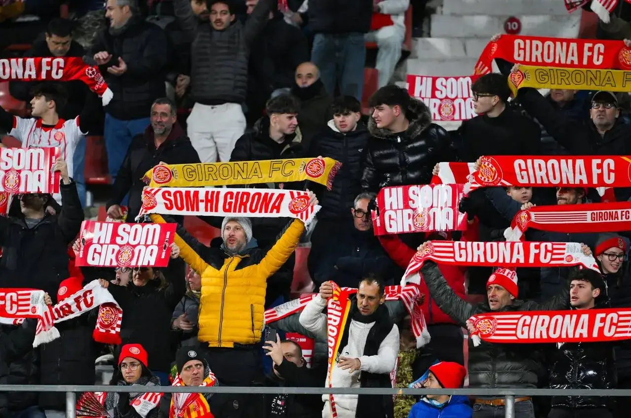 Kibice Girona FC podczas rozgrywek, trzymający szaliki z napisami 