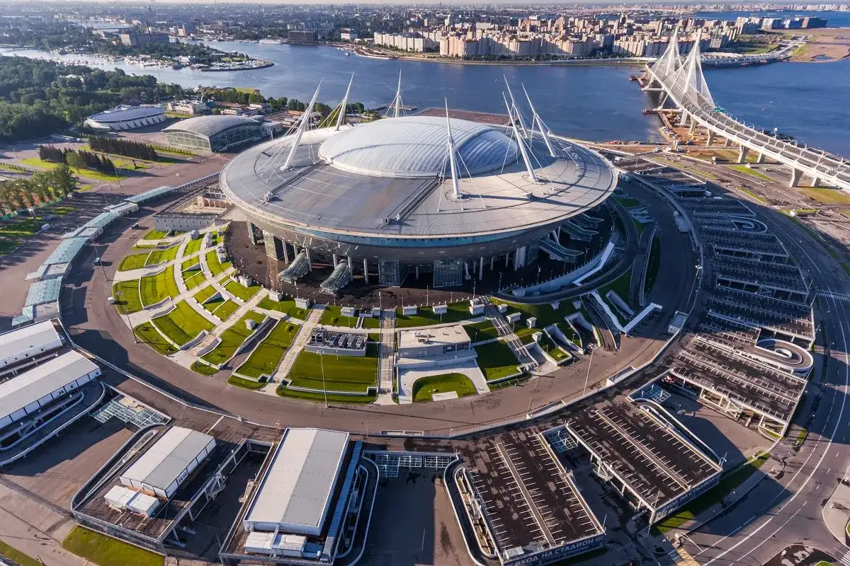 Nowoczesny stadion w Petersburgu, gotowy na emocjonujące rosja mecze. W tle widać miasto i most.