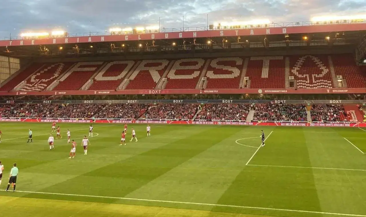 Stadion Nottingham Forest, gdzie kibice oglądają mecz ligi angielskiej. Na trybunach widać napis 